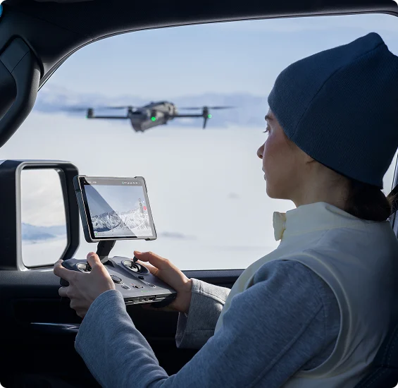 kobieta siedzi w aucie jako pasażer i steruje dronem przy pomocy kontrolera DJI RC 2 Pro