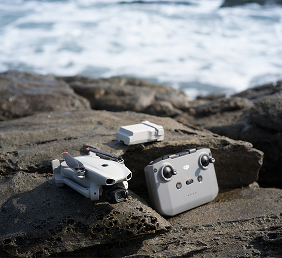 Dron DJI Lito X1, aparatura sterująca i akumulator na skale nad morzem