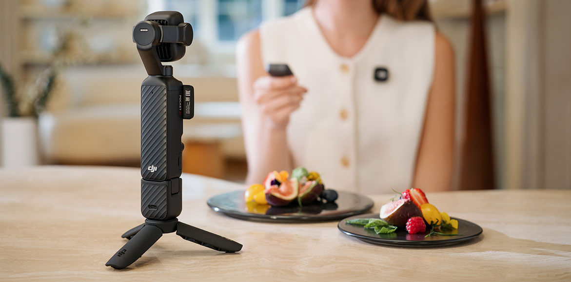 Kamera DJI Osmo Pocket 4P ustawiona na stole i nagrywająca kobietę z talerzami jedzenia