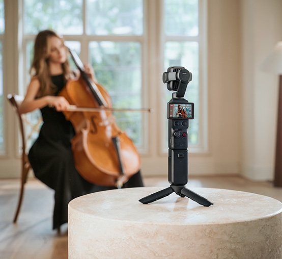 Kamera DJI Osmo Pocket 4P na mini statywie nagrywa kobietę grającą na wiolonczeli