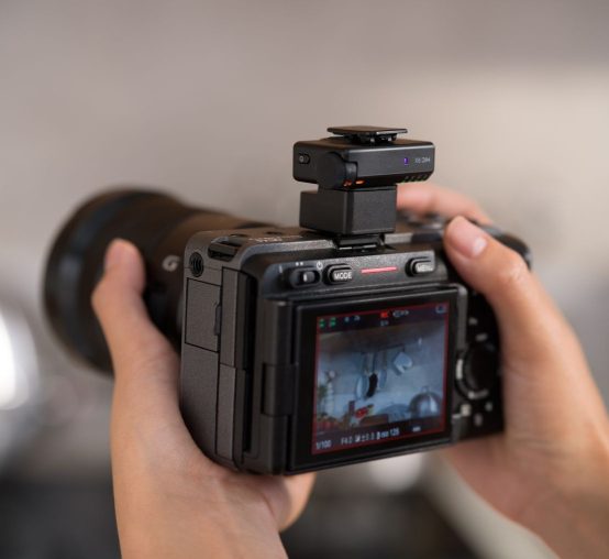 Odbiornik DJI Mic Mini 2S zamontowany na kamerze trzymanej w dłoniach