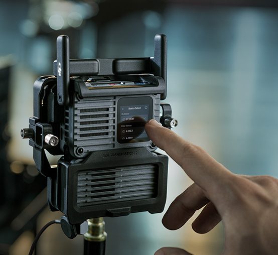 Dłoń zbliża się do ekranu DJI SDR Transmission 2