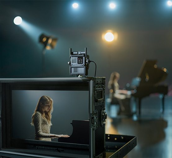 zbliżenie na obraz z kamery podłączonej do DJI SDR Transmission 2 z kobietą grającą na fortepianie
